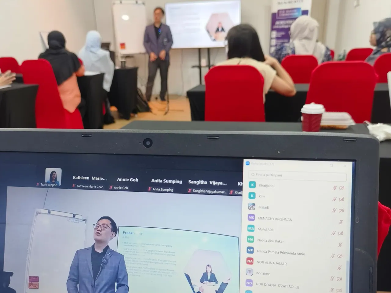 Vector Tan leading a hybrid business training session with in-room and online participants